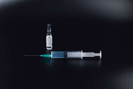 Syringe and pharmaceutical vial metal on colored ground