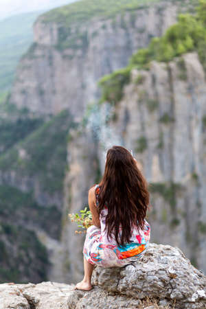 Young woman smoking a cigarette in the canyon