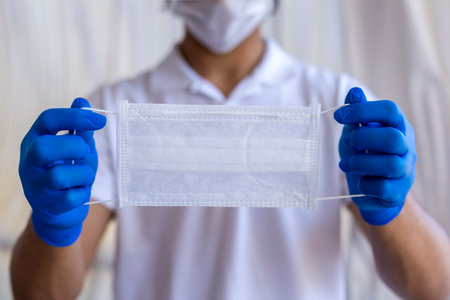 A man with a face mask in his hand