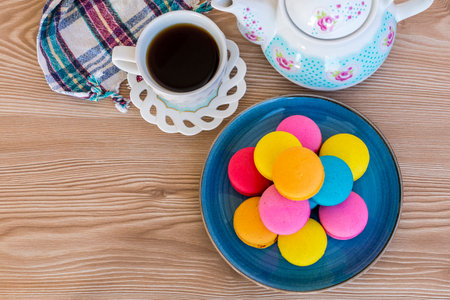 Colored macarons and tea on wooden floorの写真素材