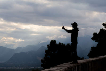 Young man making selfie with a landscape. Video calls.の写真素材