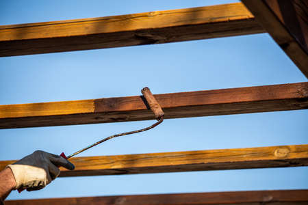 Roller with wood painting work. Dark walnut wood paintの写真素材