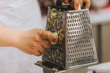 Cook's hand grating apples for apple pieの写真素材