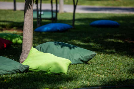 Students sitting on cushions under treesの写真素材