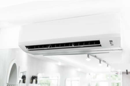 White air conditioner hanging on white walls