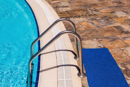 The side of the pool with stairs and tiles. The holiday season is a holiday destination, concept...