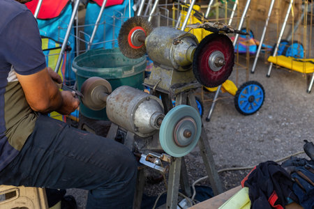 Man sharpening a knife in the market. Metal Knife