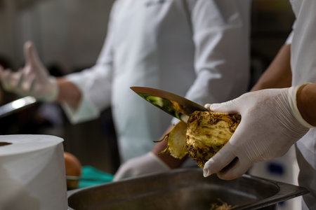 Cook's hand chopping celery in a pot. Cook chopping vegetables