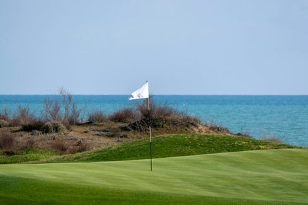 A golf course and its flag pole. Flag pole on a golf green.の写真素材
