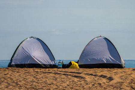 2 colorful camping tents set up for camping by the sea. Green tent, pink tentの写真素材