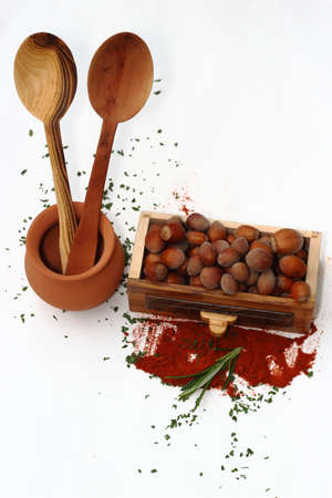 Spoons with spice rack, hazelnuts and clay potの写真素材