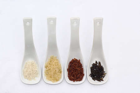 Colored rice in spoons on white backgroundの写真素材