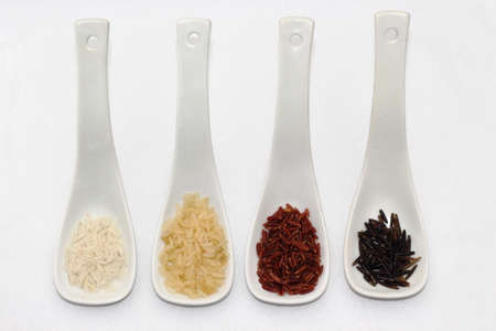 Colored rice in spoons on white backgroundの写真素材