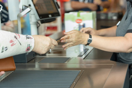 Customer paying the cashier at the supermarket with cash. Lifestyle.の写真素材