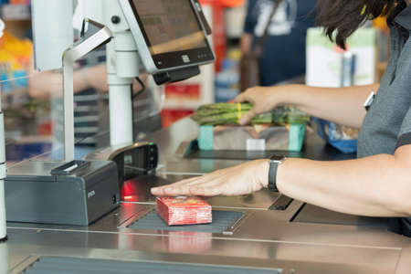 Supermarket cashier scanning items purchased by customer. Lifestyle.の写真素材