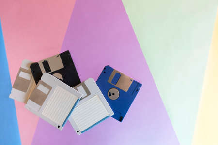 General shot, background representing elements of the 1990s. Colored cardboard creating triangular shapes and electronic storage devices, floppy disks.の写真素材