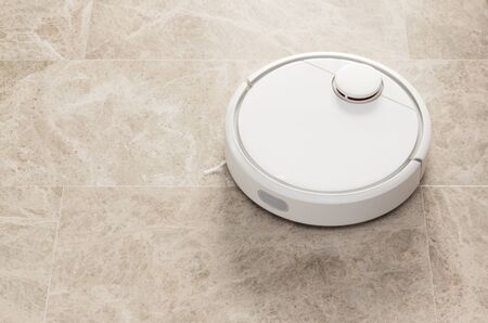 Stock photo of a robot vacuum cleaner cleaning the roomの写真素材