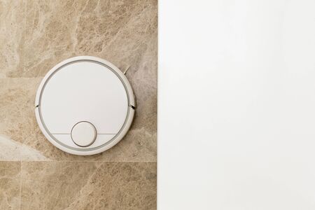 Stock photo of a robot vacuum cleaner cleaning the roomの写真素材