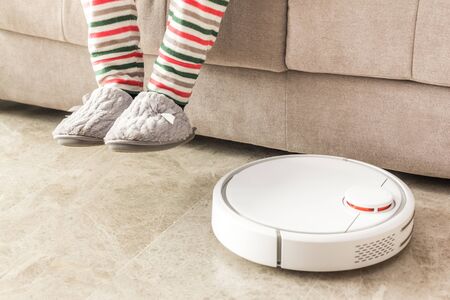 Stock photo of a robot vacuum cleaner cleaning the roomの写真素材