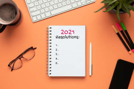 Stock photo of 2021 new year notebook with list of resolutions and objects on a salmon backgroundの写真素材