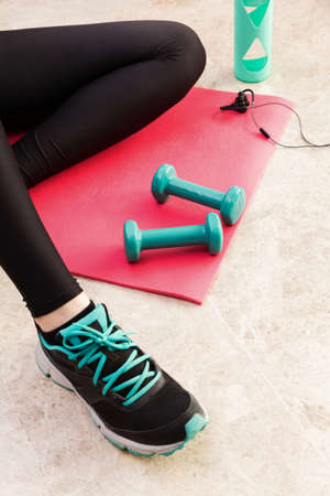 Stock photography of a young woman exercising at home in the living room