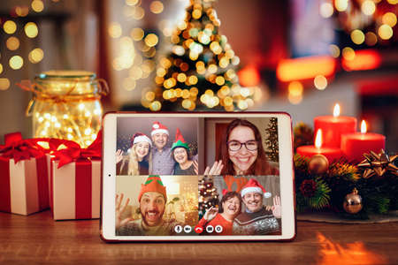 Christmas video call with the family. Concept of families in quarantine during Christmas because of the coronavirus. Xmas still life with a tablet in a cozy roomの写真素材