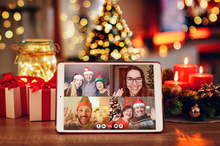 Christmas video call with the family. Concept of families in quarantine during Christmas because of the coronavirus. Xmas still life with a tablet in a cozy room