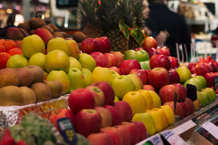 Stock photo of a market stall full of red and yellow apples among other fruits