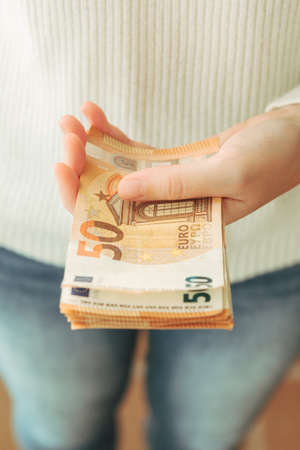 Stock photo of a woman's hands holding 50 euro bills