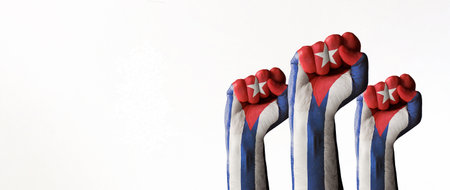 Stock photo of three raised fists with the Cuban flag paint isolated on white and copy space. SOS Cuba, Free Cuba, protests against the government fighting for freedom and democracyの写真素材