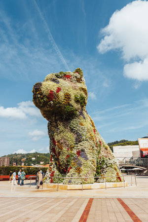 Bilbao, Spain - September, 2022: Puppy, the floral dog sculpture designed by Jeff Koons, in front of the Guggenheim museum of Bilbao, Spain on a sunny dayのeditorial素材