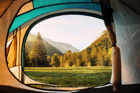 Amazing views of the valley and mountains from inside a tent during sunrise. Camping holiday and...