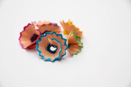Colored pencils on a white background. Wood shavings from pencils.の写真素材
