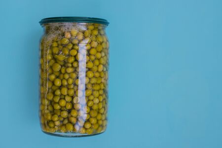 Canned green peas on a blue background. Food for donations. Food aid. Food delivery.の写真素材