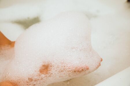 Soap suds on the hands of a child. Baby bath foam.の写真素材