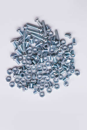 Chrome-plated screw nuts and bolts top view. Bolts and nuts on a white background. Construction...