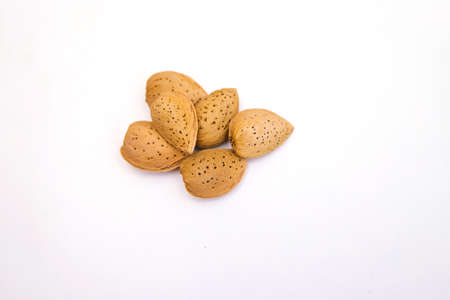 Inshell almonds on a white background. Almonds are arranged in a pile. Almond nut with texture.の写真素材