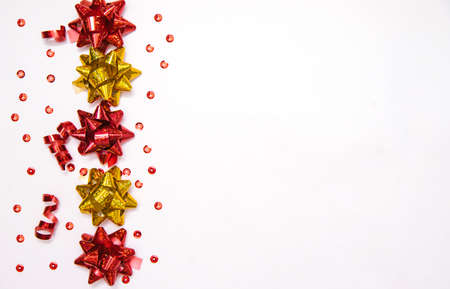 Gift bows on a white background.Confetti and candy are scattered.Christmas and New year.A birthday present. Empty space for text.の写真素材