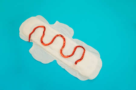 Female padding on a blue background.Medical concept photo.Gynecological menstrual cycle. Women's hygiene during critical days.の写真素材