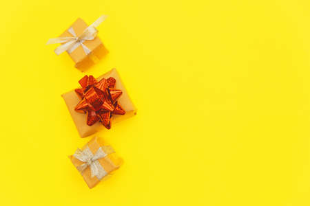 Small gift boxes on a yellow background. The concept of a holiday and gifts. Empty space for the...