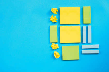 Stickers for entries of different sizes and colors are placed on a blue background.Notebooks for notes and reminders.A flat line.の写真素材