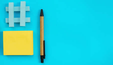 Stickers of different sizes and colors are placed on a blue background. There's a pen next to it....