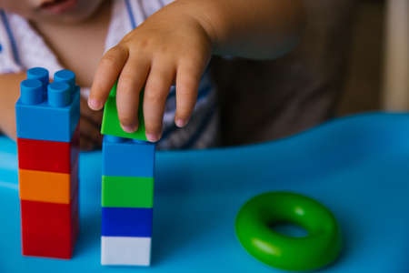 The child collects a multi-colored constructor. Children's classes in kindergarten or at home....