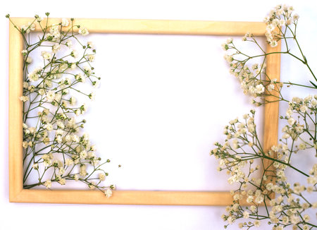 A romantic composition of flowers. White gypsophila flowers, photo frame on a white background. Valentine's Day, Easter, Birthday, Happy Women's Day, Mother's Day.Top view.の写真素材
