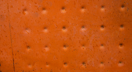 The texture of the metal painted in orange color. Rough and cracked surface. The background is made...