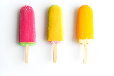 Three ice creams of different colors lie in a row on a white background. Summer refreshing dessert.Homemade sweets.の写真素材