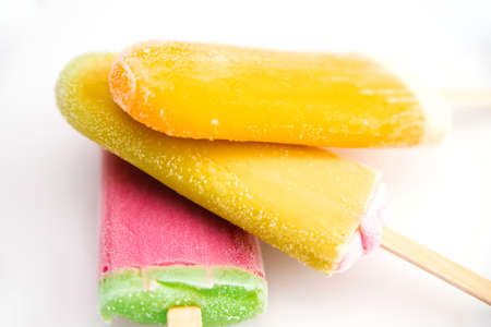Three ice creams of different colors are stacked on a white background. Summer refreshing...