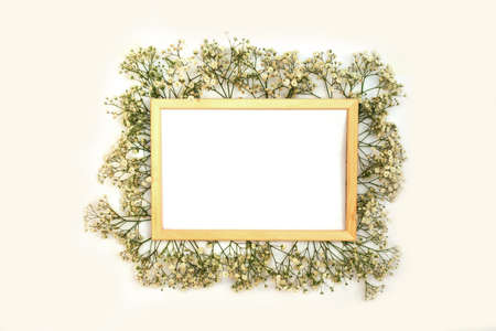 A romantic composition of flowers. White gypsophila flowers, photo frame on a white background. Valentine's Day, Easter, Birthday, Happy Women's Day, Mother's Day.Top view.の写真素材