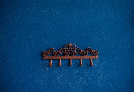 Metal hooks on the background of a blue wall. Plaster on the wall. rough uneven surface. Vintage background and texture.の写真素材