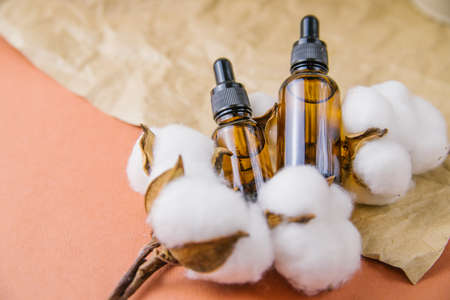 The concept of aromatherapy with a bottle of essential oil, cotton flowers. Composition of a still...